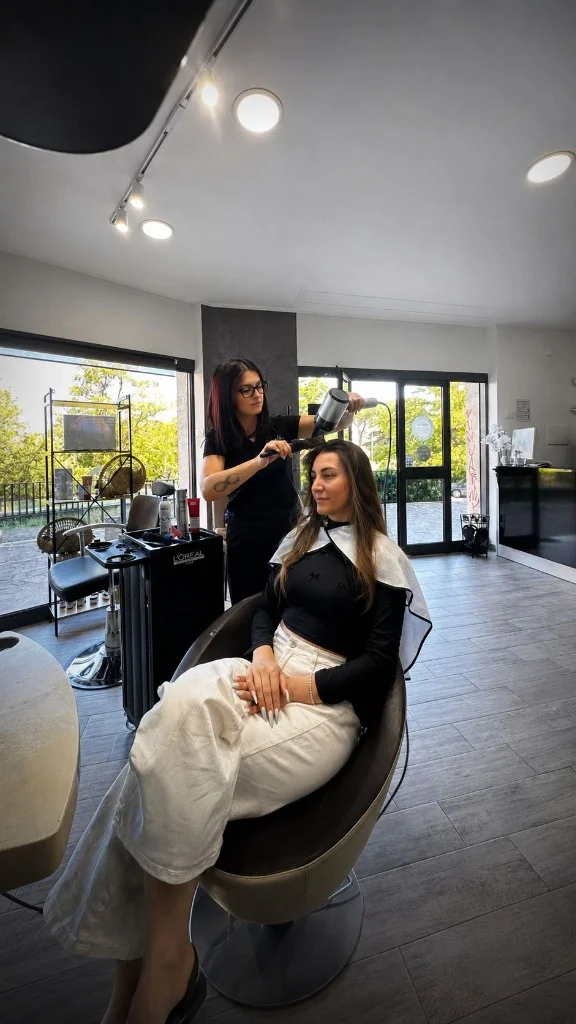 Parrucchiera esegue piega professionale su cliente nel salone